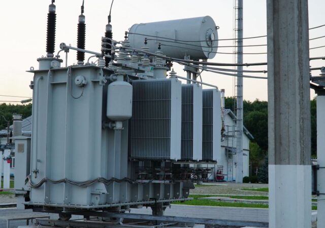 Power transformer. Electrical equipment. Electric substation. High voltage transformer against the blue sky. Electric current redistribution substation.
